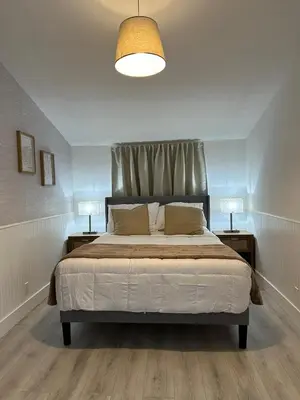 a bedroom with a large bed with two nightstands and two lamps at Cozy Corner in Miami