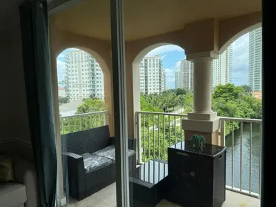 a balcony with a couch and a view of a city at The Costal, stunning water view apartment at Aventura Yacht Club, Miami Florida! in Sun Swept Isles