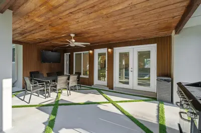 a patio with a table and chairs and a ceiling at Villa Verde - Your Exclusive Luxury Escape with Private Pool and Mini Golf in Miami