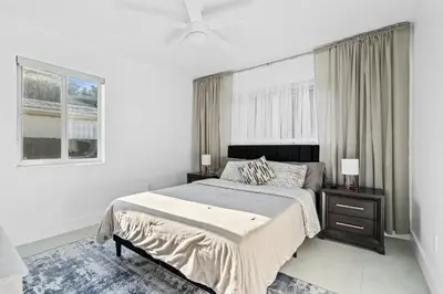 a white bedroom with a large bed and a window at Villa Verde - Your Exclusive Luxury Escape with Private Pool and Mini Golf in Miami