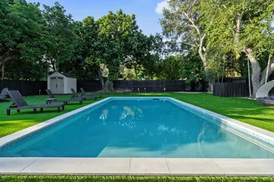 a swimming pool in a yard with two benches at Villa Verde - Your Exclusive Luxury Escape with Private Pool and Mini Golf in Miami