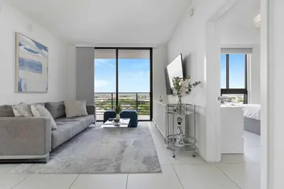 a living room with a couch and some windows at La Central- CityPlace Doral and across from a Park in Miami