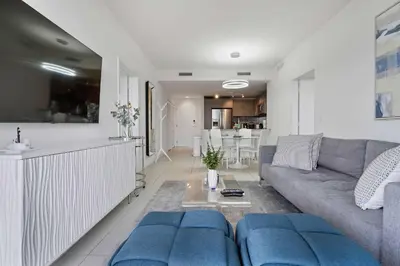 a living room with a couch and a kitchen at La Central- CityPlace Doral and across from a Park in Miami