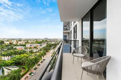 a balcony with chairs and a view of a city at La Central- CityPlace Doral and across from a Park in Miami