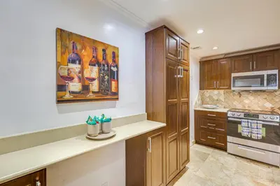 a kitchen with a painting of wine bottles on the wall at Hollywood Condo with Beach Access - Walk to Shore! in Hollywood