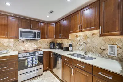 a kitchen with wooden cabinets and a sink at Hollywood Condo with Beach Access - Walk to Shore! in Hollywood