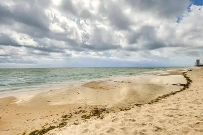 a sandy beach with the ocean on a cloudy day at Hollywood Condo with Beach Access - Walk to Shore! in Hollywood