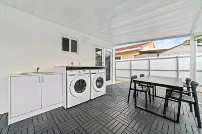 a kitchen with a washing machine and a table with chairs at Luxurious Family Escape in Hialeah