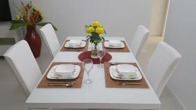 a white table with plates and a vase of flowers on it at Downtown Hollywood Boutique Hotel in Hollywood