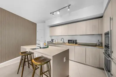 a kitchen with a counter and two bar stools at Breathtaking Ocean-View Balcony Lyfe Resort in Hollywood Beach