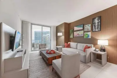 a living room with a white couch and a tv at Breathtaking Ocean-View Balcony Lyfe Resort in Hollywood Beach