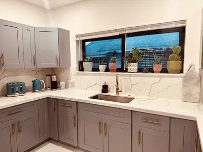 a kitchen with white cabinets and a sink and a window at Charming Home Close to Beaches & Downtown in Miami