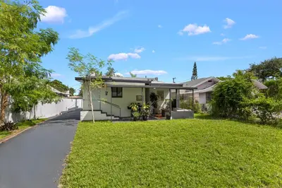a house with a lawn in front of it at Charming Home Close to Beaches & Downtown in Miami