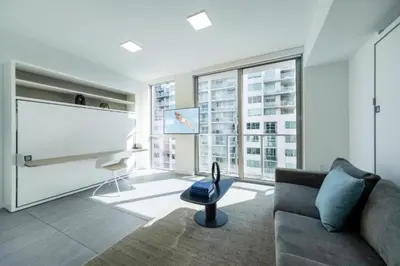 a living room with a couch and a large window at Spacious Studio in the Heart of Downtown Miami in Miami