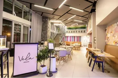 a restaurant with tables and chairs and a sign at Spacious Studio in the Heart of Downtown Miami in Miami