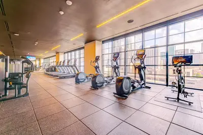 a gym with treadmills and ellipticals in a building at Magic Miami Penthouse, Ocean & City Views, Pool, Spa, Gym, in Miami