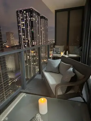 a living room with a couch and a candle on a balcony at Magic Miami Penthouse, Ocean & City Views, Pool, Spa, Gym, in Miami