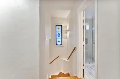 a hallway with white walls and a stained glass window at Stunning Historic Villa with Jacuzzi Heated Pool and Resort style Backyard in Miami
