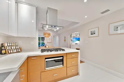 a kitchen with white counters and a stove top oven at Stunning Historic Villa with Jacuzzi Heated Pool and Resort style Backyard in Miami