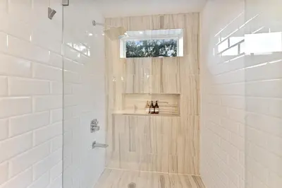 a white bathroom with a shower and a window at Stunning Historic Villa with Jacuzzi Heated Pool and Resort style Backyard in Miami