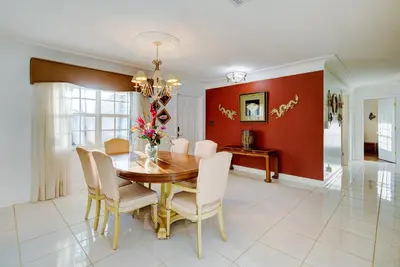 a dining room with a wooden table and chairs at Classic Modern 3-Bedroom Oasis in Fort Lauderdale