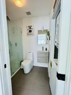 a bathroom with a toilet and a sink and a shower at Charming House at Miami's Heart in Miami