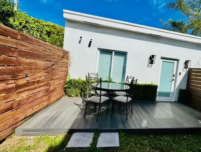 a patio with a table and chairs in front of a fence at Charming House at Miami's Heart in Miami