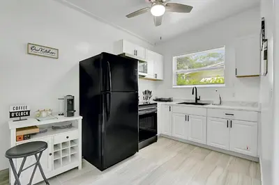 a black refrigerator in a kitchen with white cabinets at Fort Lauderdale Home near Nightlife and Beach in Fort Lauderdale