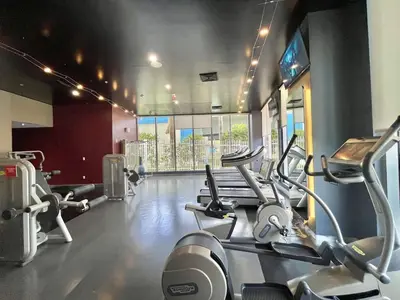 a gym with several cardio machines in a room at Beachwalk - 1 Bedroom & Kitchen Amazing Bay view in Hallandale Beach