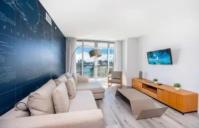a living room with a couch and a large wall at Beachwalk - 1 Bedroom & Kitchen Amazing Bay view in Hallandale Beach
