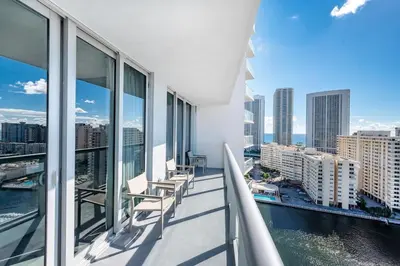 a balcony with chairs and a view of the city at 2 Bed 2 Bath With Amazing Bay View And Luxury Pool in Hallandale Beach