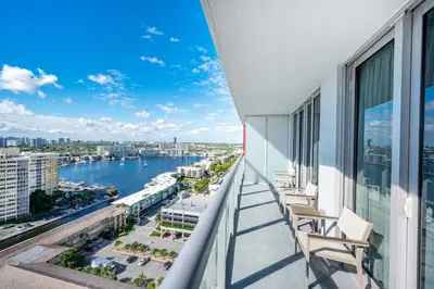 a balcony with chairs and a view of the water at 2 Bed 2 Bath With Amazing Bay View And Luxury Pool in Hallandale Beach