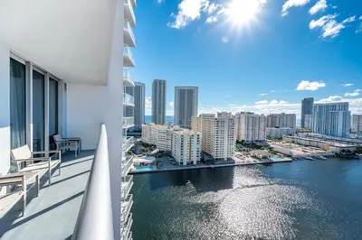 a balcony with a view of a river and buildings at 2 Bed 2 Bath With Amazing Bay View And Luxury Pool in Hallandale Beach
