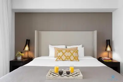 a bedroom with a bed with a tray of orange juice at Beautiful apartment with Amazing Pool Balcony in Hollywood