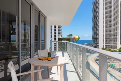 a balcony with a table and a bottle of wine at Beautiful apartment with Amazing Pool Balcony in Hollywood