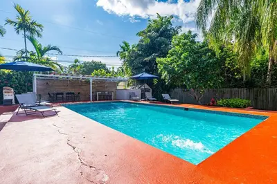 a swimming pool in a backyard with an orange floor at Spacious 3 bedroom Home with Oversized Pool & Backyard in Miami