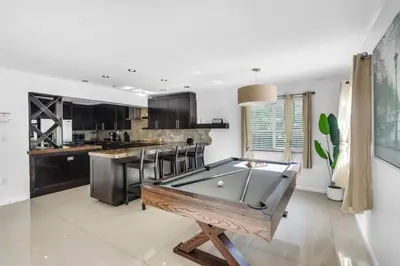 a kitchen with a pool table in the middle of it at Spacious 3 bedroom Home with Oversized Pool & Backyard in Miami