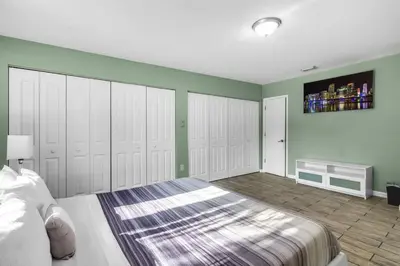 a bedroom with a large bed with white closets at Spacious 3 bedroom Home with Oversized Pool & Backyard in Miami