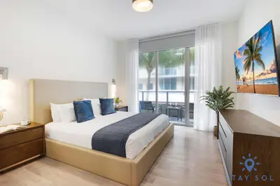 a bedroom with a large bed and a large window at Beautiful Apt 2BR Hollywood Beach Rooftop Pool in Hollywood