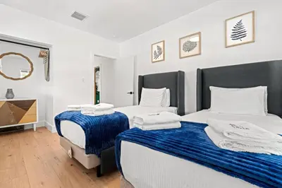 a bedroom with two beds with blue and white sheets at Farfalla XX in Miami