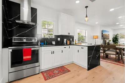 a kitchen with white cabinets and black appliances at Farfalla XX in Miami
