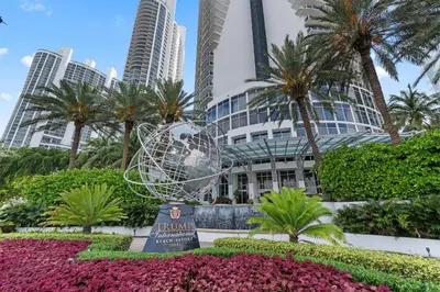 a sculpture in front of a building with palm trees at Lujoso apartamento en playa de Sunny Isles Beach in Sunny Isles Beach