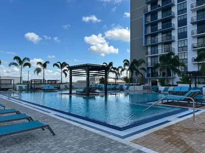 a large swimming pool with a gazebo next to a building at Luxury apartment in Doral miami, 1 Bd in Miami