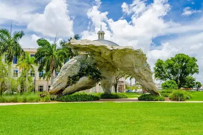 a sculpture in a park in front of a building at Comfortable Studio suites in downtown Doral in Miami