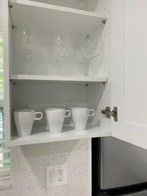 a shelf with cups and wine glasses on it at Newly renovated studio close to the beach in Hollywood