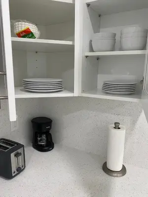 a kitchen counter with plates and a roll of paper towels at Newly renovated studio close to the beach in Hollywood