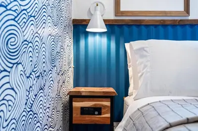 a bedroom with a bed and a blue wall at The SurfSide Hideout Charming Cozy Central in Miami