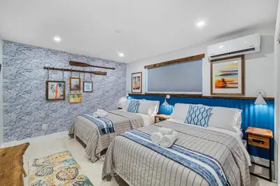 a bedroom with two beds and a flat screen tv at The SurfSide Hideout Charming Cozy Central in Miami