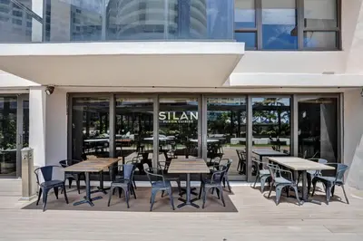 a restaurant with tables and chairs in front of a building at High Floor Adorable 2 Bedroom Condo Resort 1606 in Miami Beach