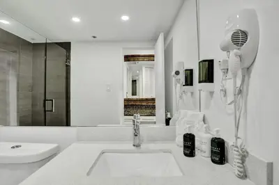 a white bathroom with a sink and a mirror at Adorable 2 Bedroom Condo Beach Service 1110 in Miami Beach